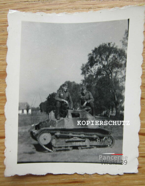 [TKS][#520]{003}{a} (bei Ostrowice) pionowe pasy, przy drodze we wsi, białe budynki, z tyłu figura.jpg